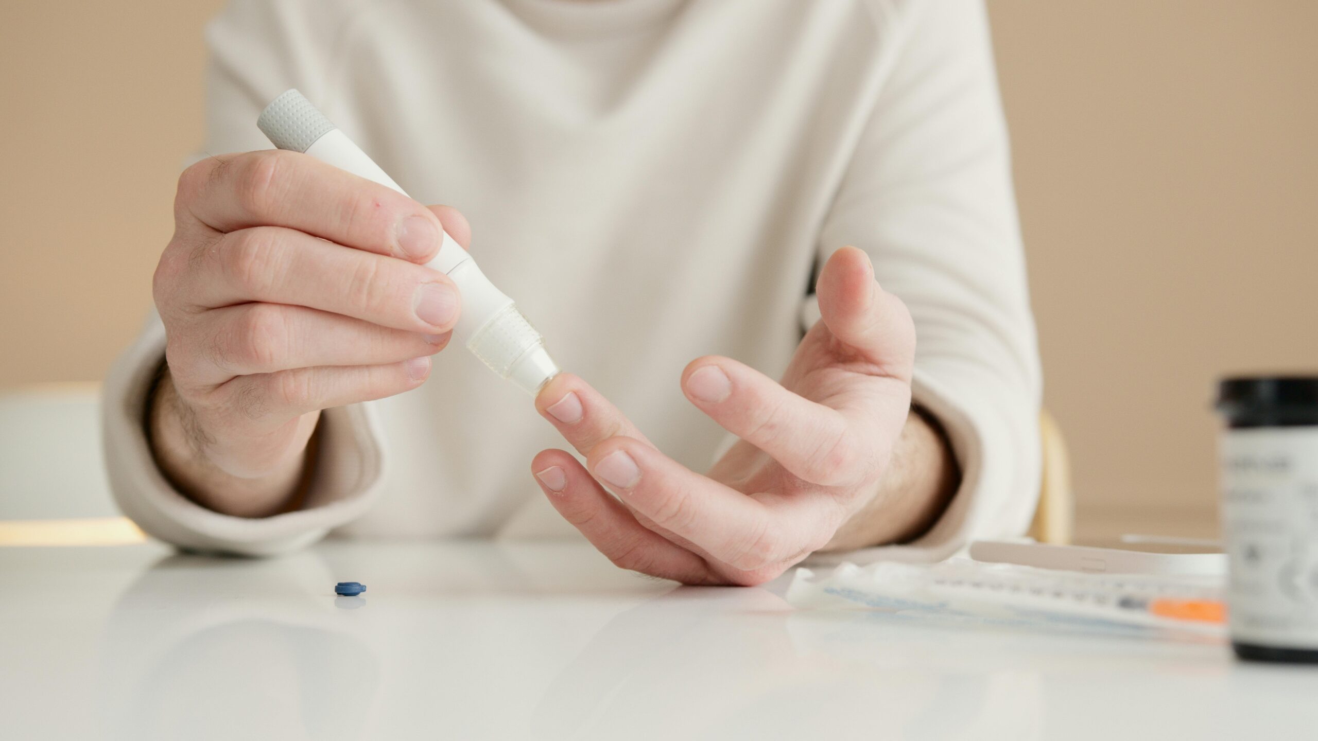 Close-up of a person using a glucometer to test blood sugar at home.